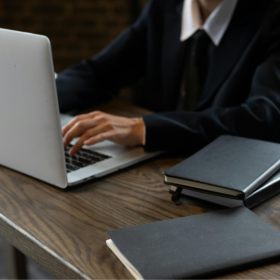 avocat dragos dubalari - barbat in costum ce lucreaza la laptop pe un birou de lemn